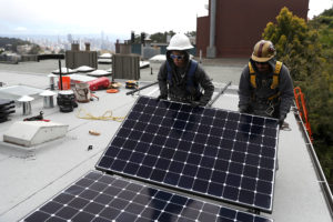 工人们在旧金山的一户人家安装太阳能电池板，该市限制了新建筑中使用天然气。