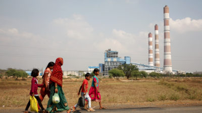 一个女人和孩子们走过印度Chhattisgarh的燃煤电厂。