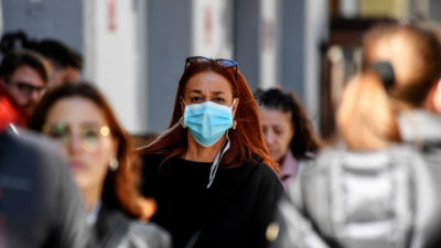 本月，在意大利那不勒斯，一名妇女戴着面具走在大街上。该国受到冠状病毒的严重打击。