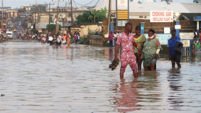 居民于7月穿过尼日利亚拉各斯阿博鲁市洪水淹没的道路。