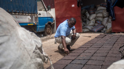 在加纳的阿克拉郊区，一名工程师正在检查由回收塑料制成的铺路石。