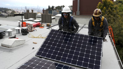 工人在旧金山的房屋上安装太阳能电池板，这已经限制了新建的天然气的使用。