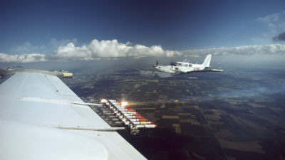 在飞行在北部达科他的飞机翼的云种播种设备。