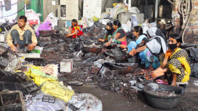 在印度巴特那，工人们拆除汽车电池，为铅回收做准备。