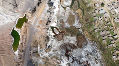 烟雾包围了塞昆达的沙索合成燃料工厂。右图:9月普马兰加省eMalahleni的一个煤矿中流出的酸性水的鸟瞰图。
