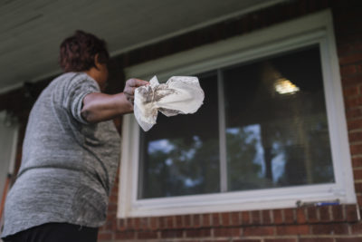 克莱尔顿居民从她家的窗户上擦拭烟灰。