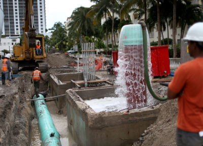 工人在迈阿密海滩安装水泵系统来打击海平面上升的水平。
